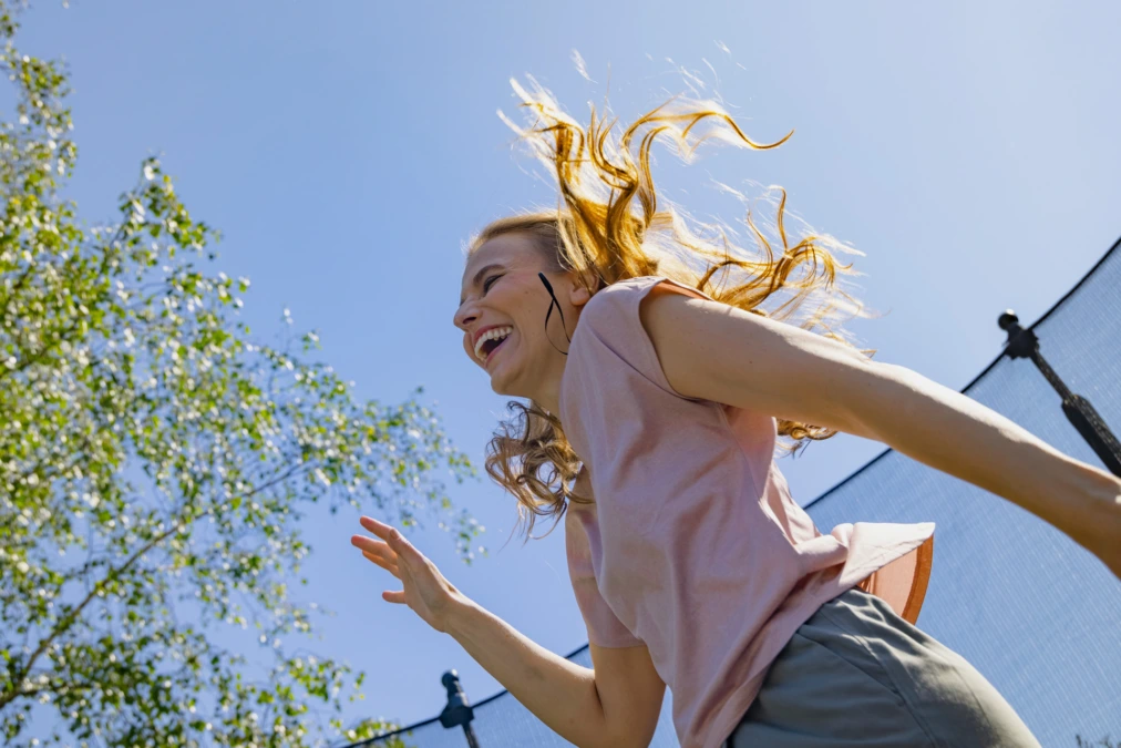 A woman jumps and looks happy.