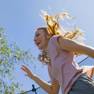 A woman jumps and looks happy.