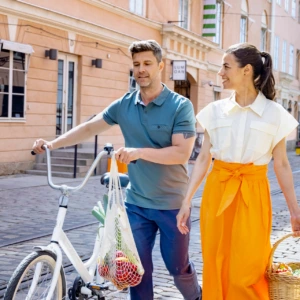 A woman and a man are walking with a bicycle.