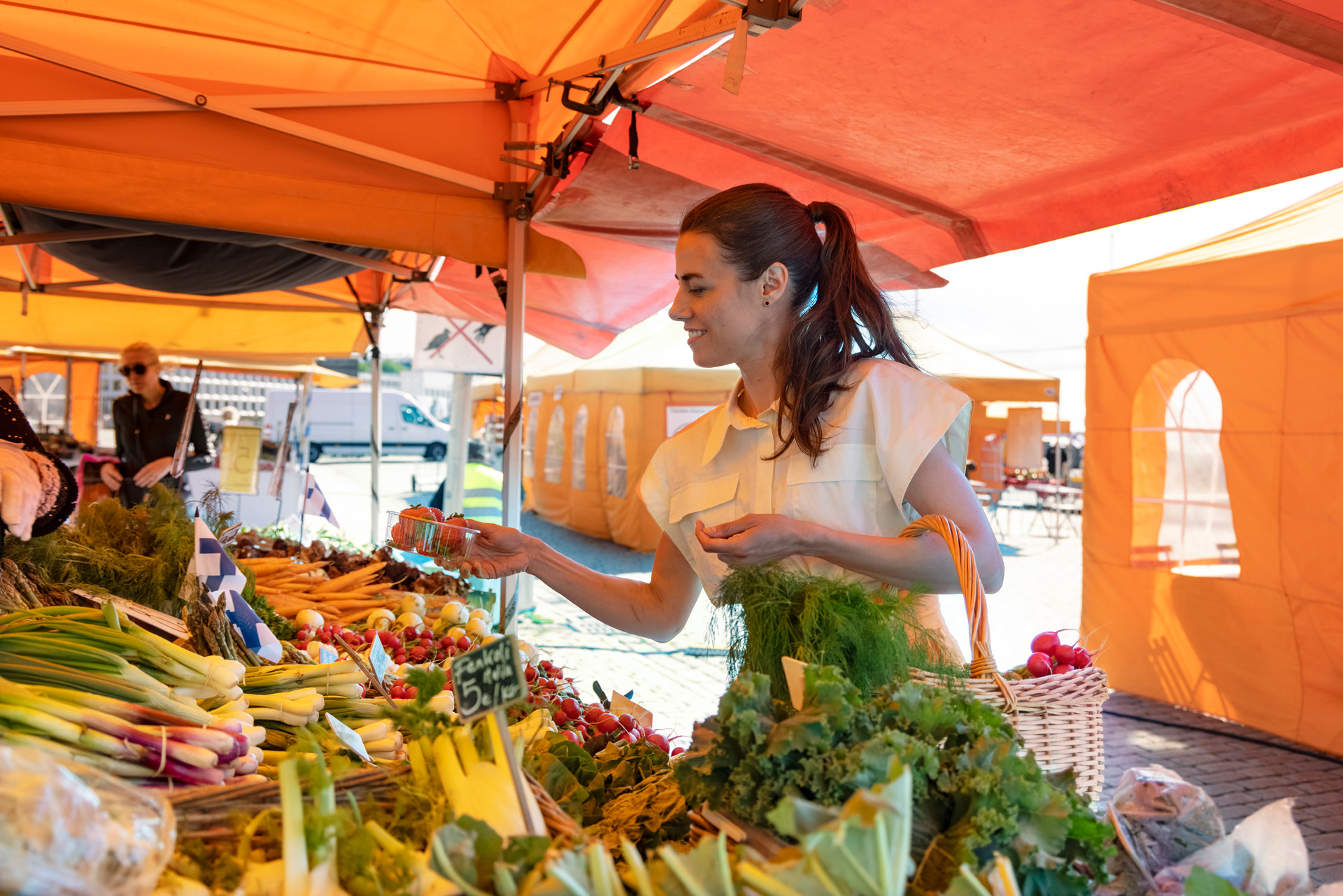 The woman is buying vegetables at the market.