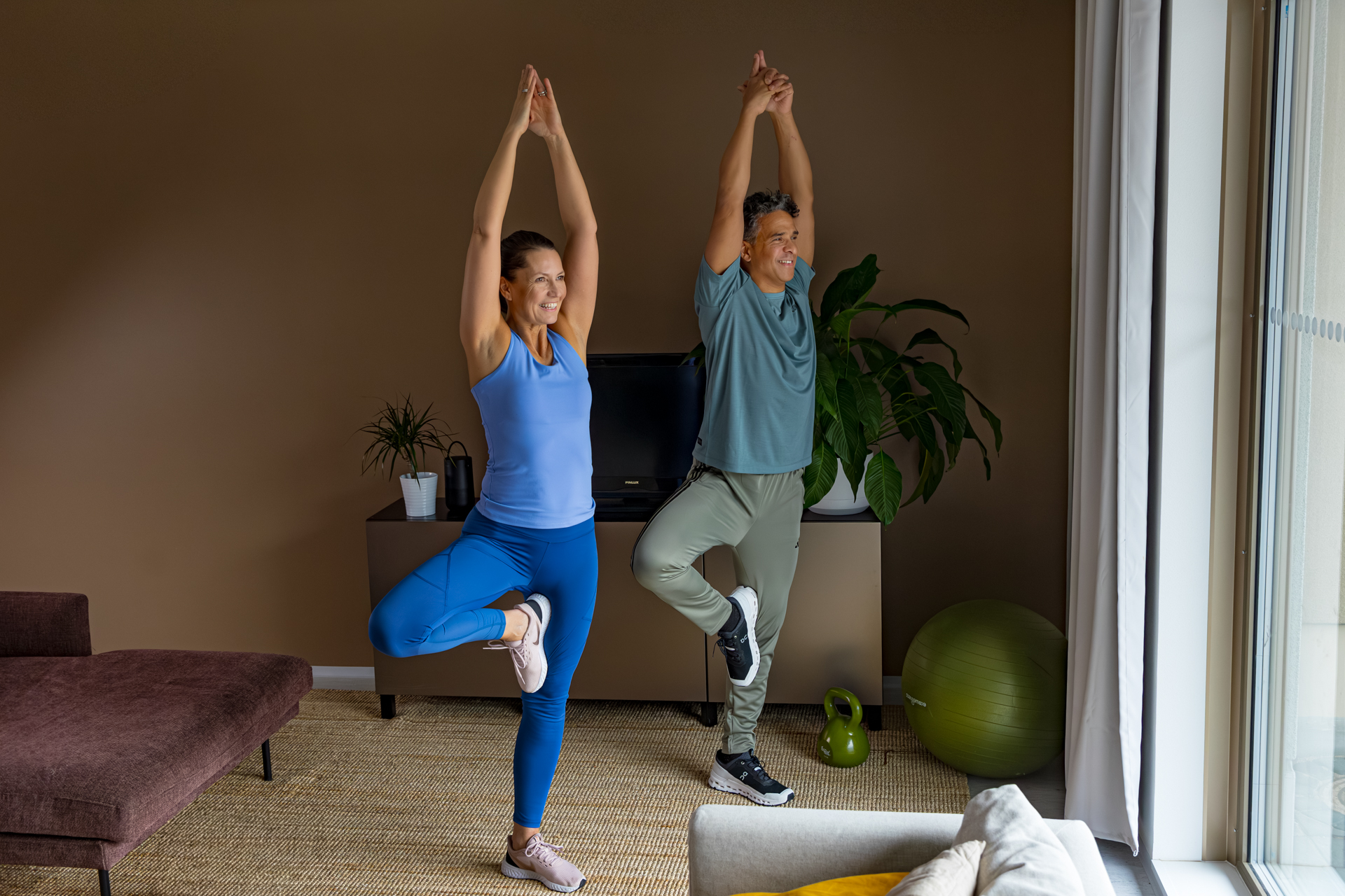 Two people standing in a yoga position