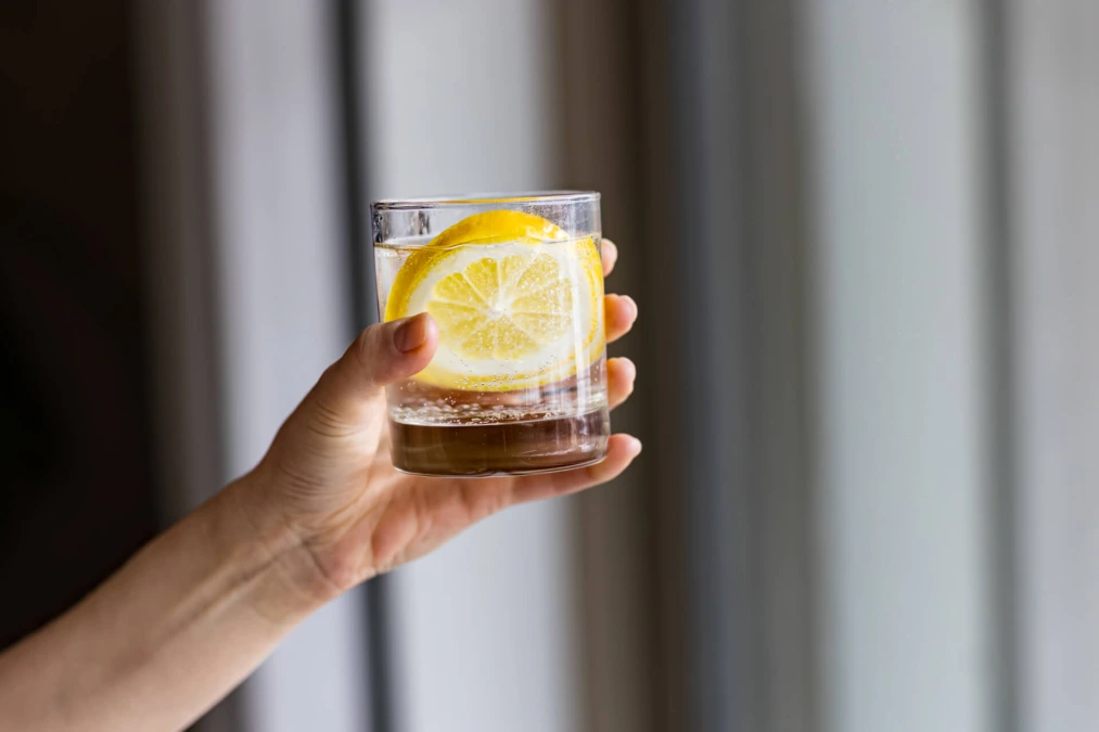 Illustrativ bild på ett glas vatten med en citronskiva.