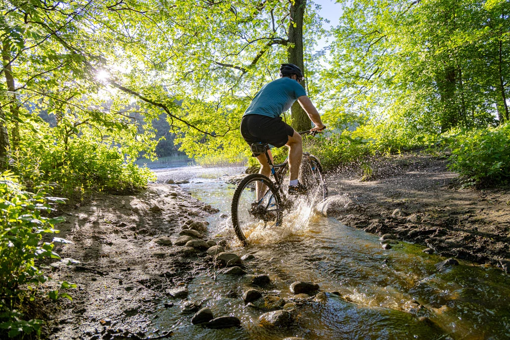 Dekorativ bild på en man som cyklar ute i naturen